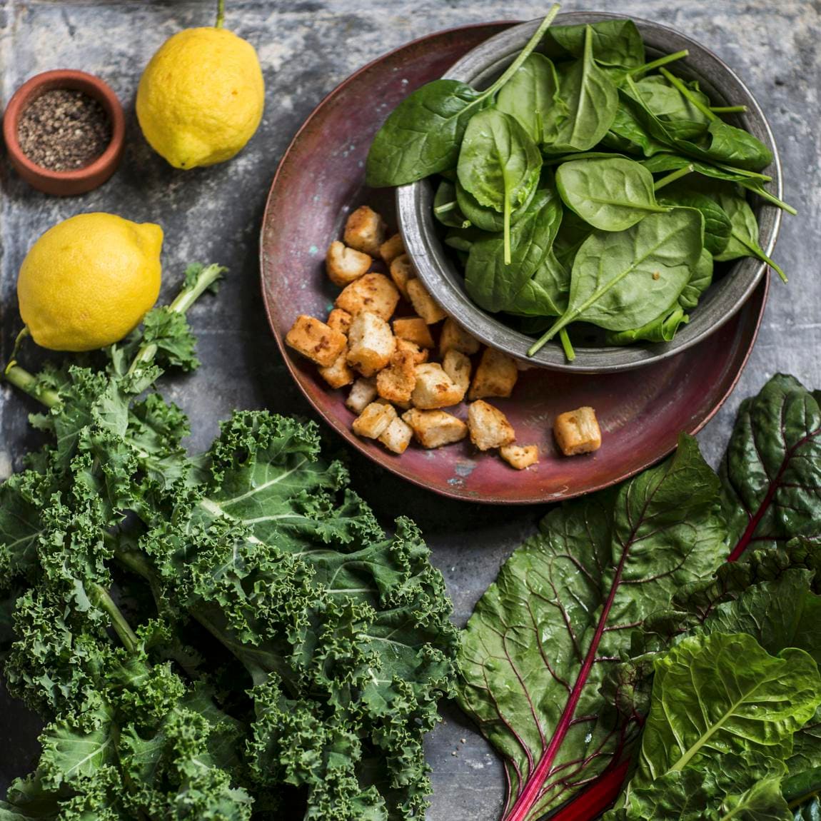 Ingredients for a salad with kale, spinach, chard and croutons