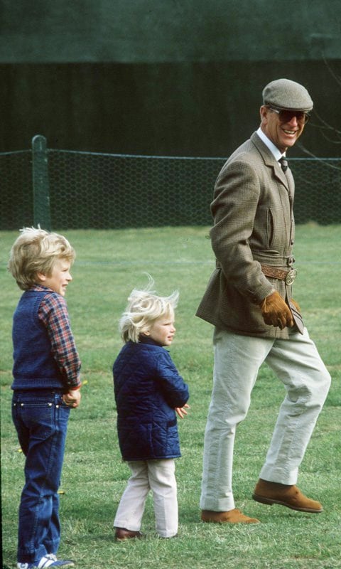 Following the leader! The Queen’s husband was dressed to the nines as he strolled the grounds of the 1984 Royal Windsor Horse Show with Peter and Zara Phillips behind him.